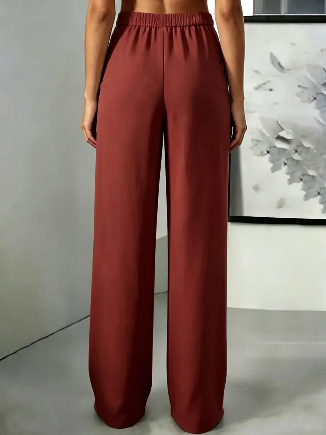 Pantalons à jambes larges, taille haute, en couleur rouille, avec des jambes amples et une ceinture élastique conçue pour un ajustement confortable.