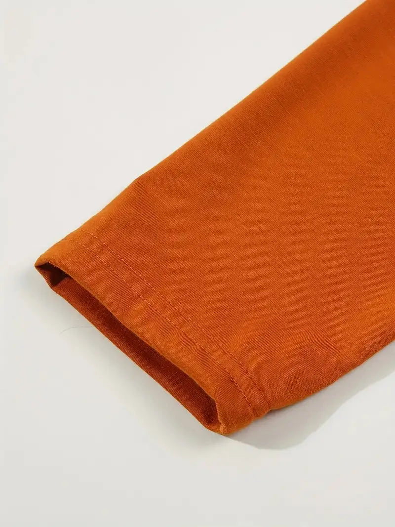 Das Ärmelbündchen eines orangen Baumwoll-Polohemds mit langen Ärmeln im Casual-Sporttop-Stil ist sauber umgelegt.