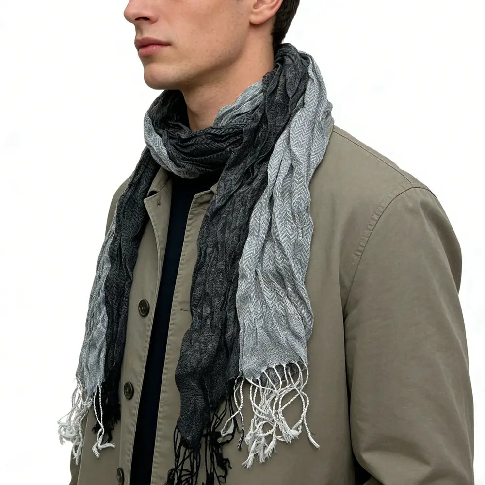 Écharpe longue d’hiver en polyester jacquard gris pour femmes, avec un motif chevron texturé dégradé gris et des bords effilochés.