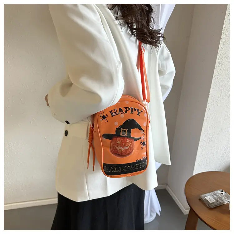 Orange embroidered halloween floral and pumpkin crossbody bag featuring a jack-o-lantern and witch hat design with black text and spider details.