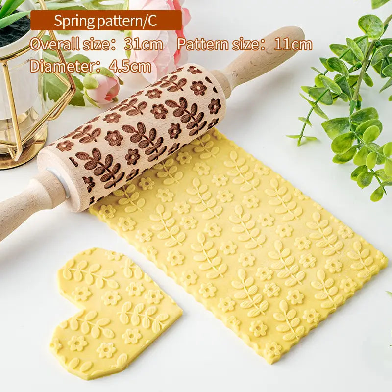 Un rouleau à pâtisserie en bois de hêtre en relief floral pour la cuisson, présentant un motif printanier sculpté brun foncé sur le fil naturel du bois.