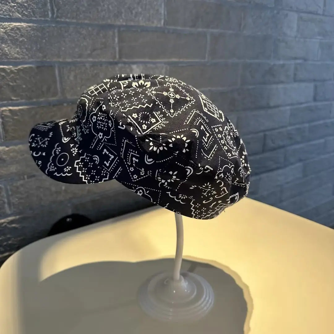 Gorra tipo bucket hat floral con patrón de bandana negra, estilo coreano, impresa, con diseños geométricos y florales blancos.