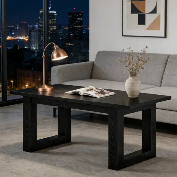 Schreibtisch aus schwarzem Holz mit robusten rechteckigen Beinen und glatter, dunkel lackierter Oberfläche, ausgelegt als moderne minimalistische Arbeitsstation.