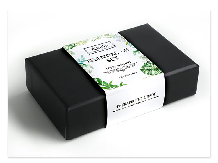 Schwarze rechteckige Box mit weißem Etikett, das ein grünes Blattdesign zeigt, sowie dem Text kanho für das ätherische-Öl-Set, Teil des ätherischen-Öl-Sets mit Holz-Diffusor, 4er-Set