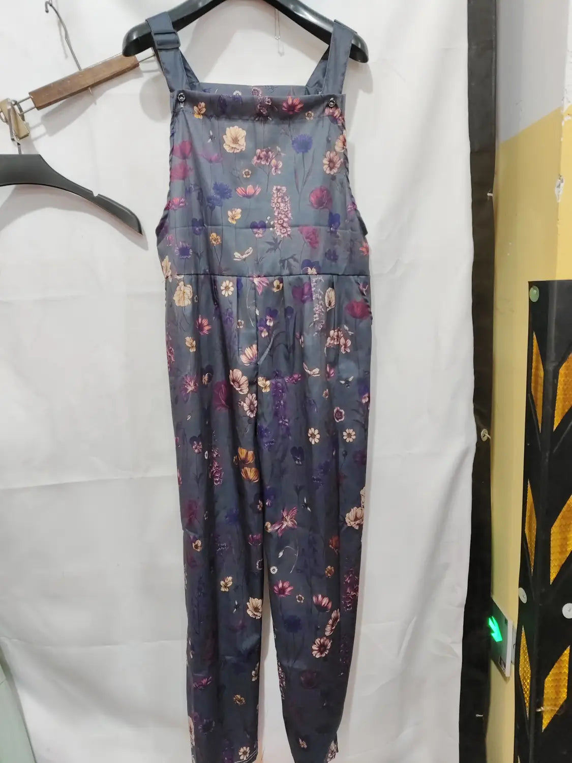 Dark gray floral-patterned denim printed suspender overalls with a gathered waist and adjustable shoulder straps for casual wear.