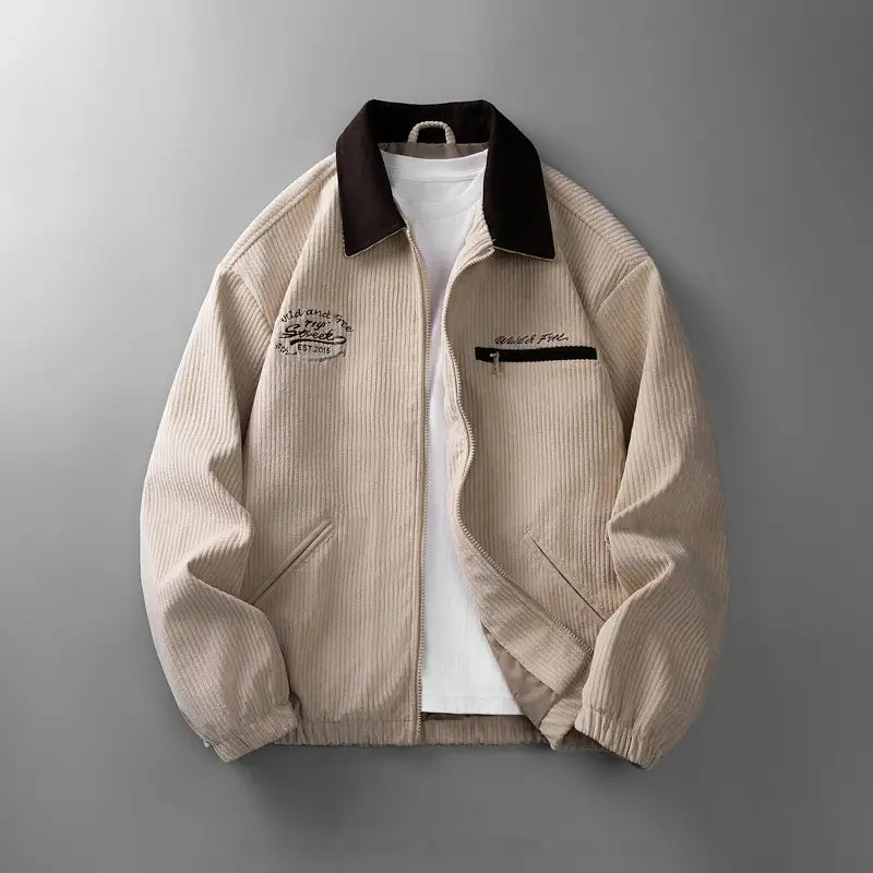 Herren-Lifestyle-gestickte Cord-zipjacke in Beige mit kontrastierendem dunkelbraunem Kragen und einer gestickten Applikation auf der linken Brust.