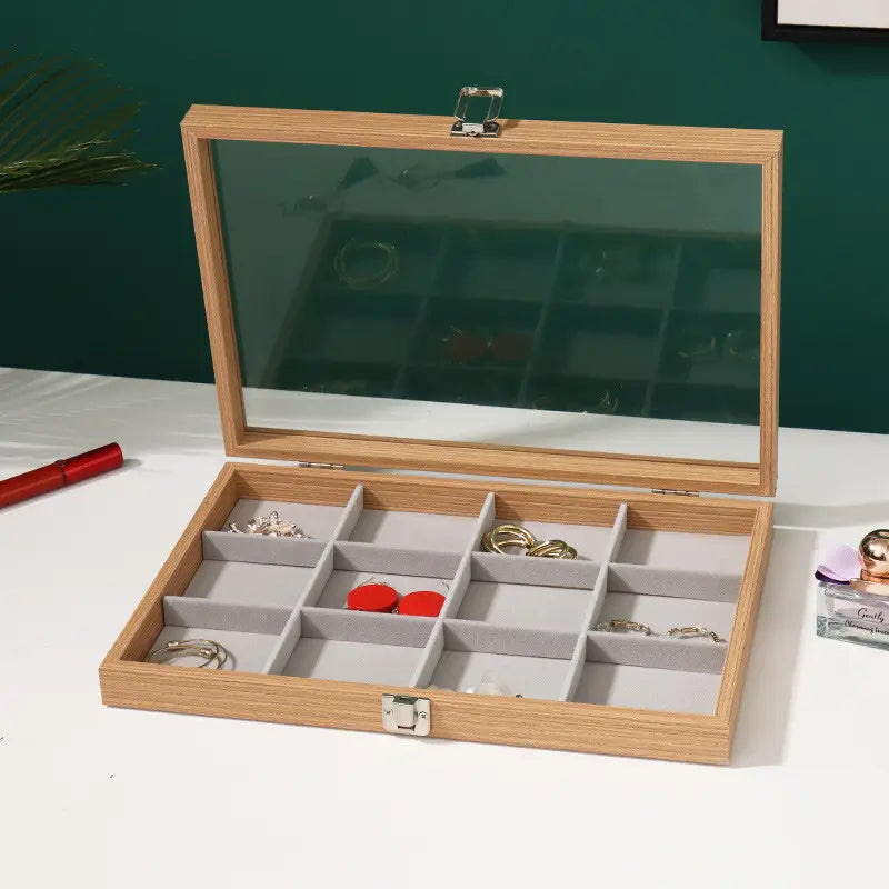 Rosewood jewelry display box with a light wood finish, clear glass lid, and gray felt-lined compartments for organized storage.