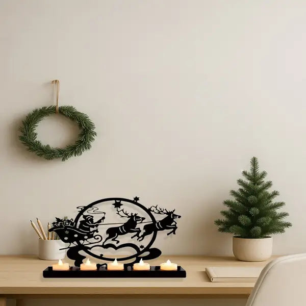 Photophore en fer ancien de Noël, en métal noir, représentant la scène du traîneau du Père Noël tiré par des rennes, avec cinq bougies allumées.