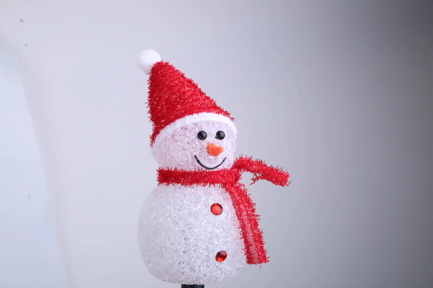 Un brise-soleil de jardin de bonhomme de neige à LED blanc festif, avec un bonnet et une écharpe rouges texturés, des yeux à boutons noirs et un nez en forme de carotte orange, avec des lumières internes éclairées, en lot de 3, ensemble étanche IP55.