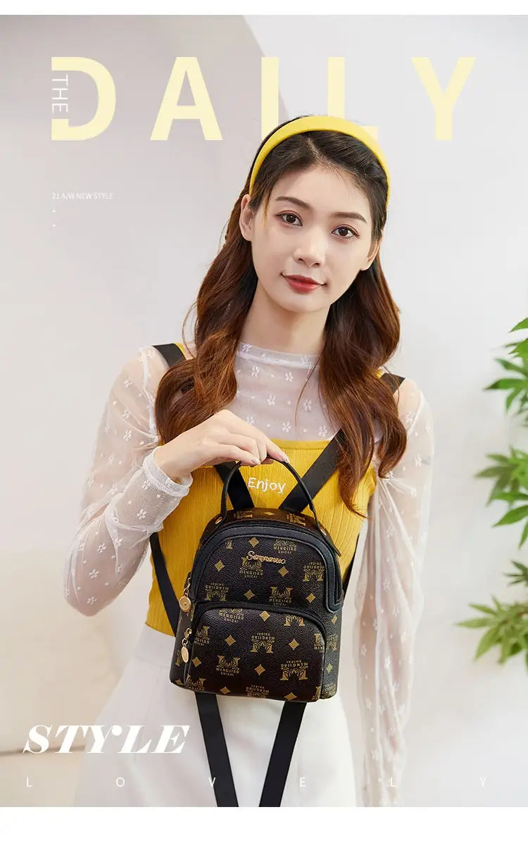 Black mini backpack with gold cow and snake print monogram pattern and black straps in Korean style.