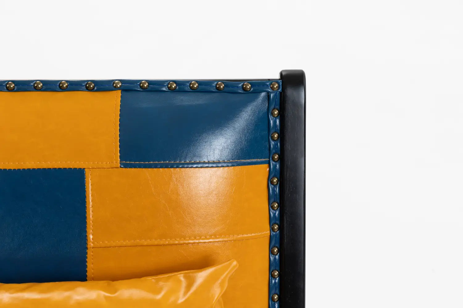 Moderner Boho-Akzent-Sessel mit blau-gelbem Leder-Patchwork und Messing-Nieten entlang der Kante für eine stilvolle Lounge-Sitzgelegenheit.