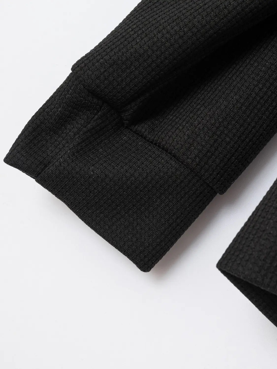 black waffle knit sleeve cuff on men waffle knit zip cardigan jacket made of textured knit fabric