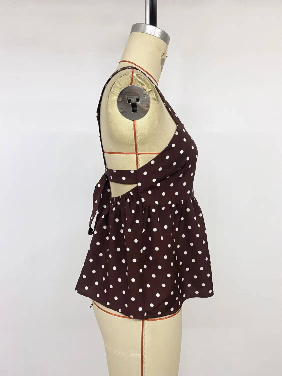 Brown polka dot peplum camisole featuring a halter top style with white dots and a tied waistband.