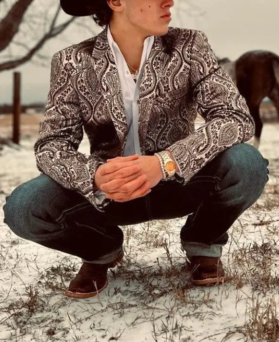Ein Mann trägt einen schwarzen und weißen Paisley-Muster-Blazer Slim Fit mit aufwendigen Details, tailliert für den lässigen Einsatz.