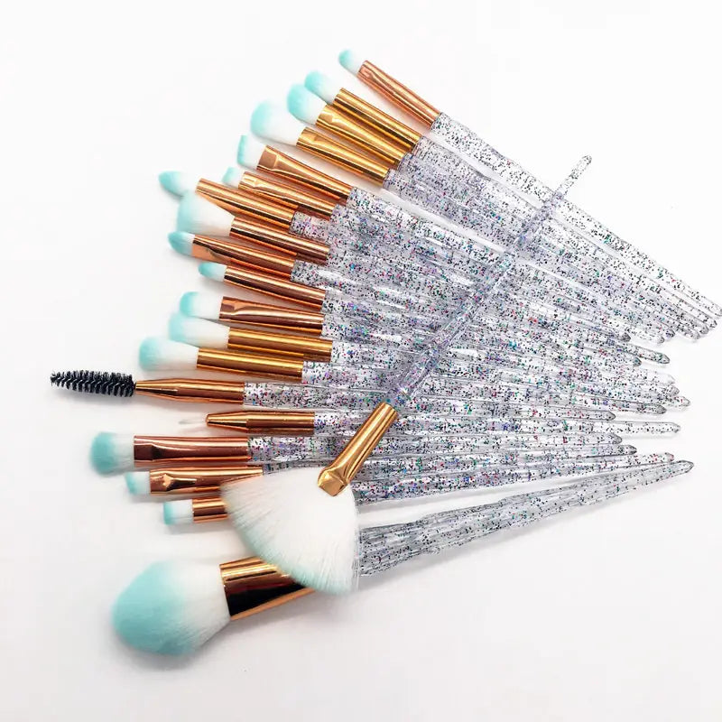 Set of 20 makeup brushes with glittery clear handles, rose gold ferrules, and light blue-tipped bristles designed for cosmetic application.