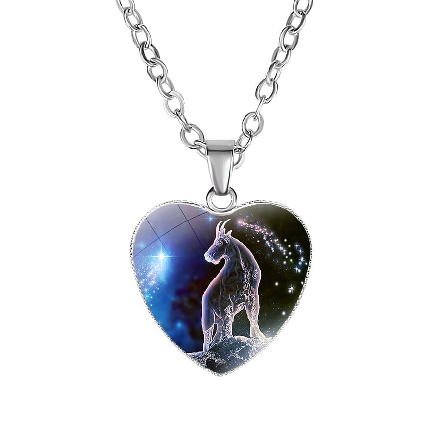 Silver heart-shaped pendant necklace featuring a detailed Capricorn zodiac sign against a cosmic stars and nebulae background in a zodiac celestial heart pendant galaxy constellation necklace.