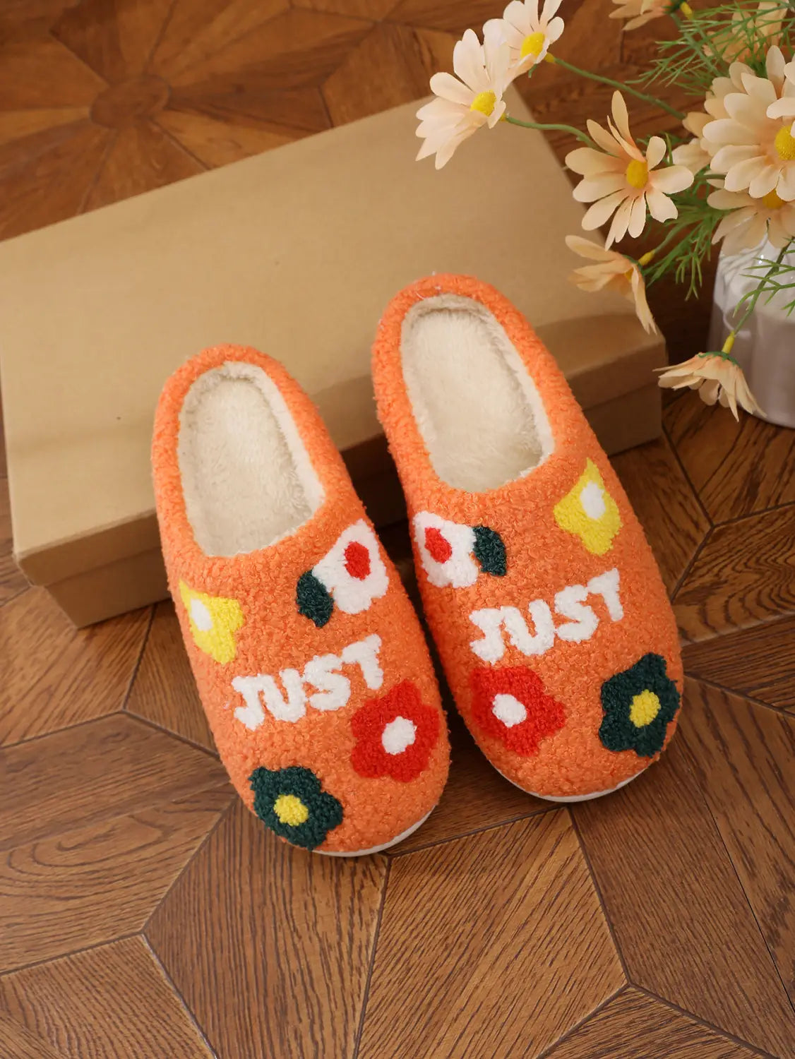 plush floral cotton slippers in orange with soft tpr sole featuring embroidered floral patterns and the word just in white lettering.