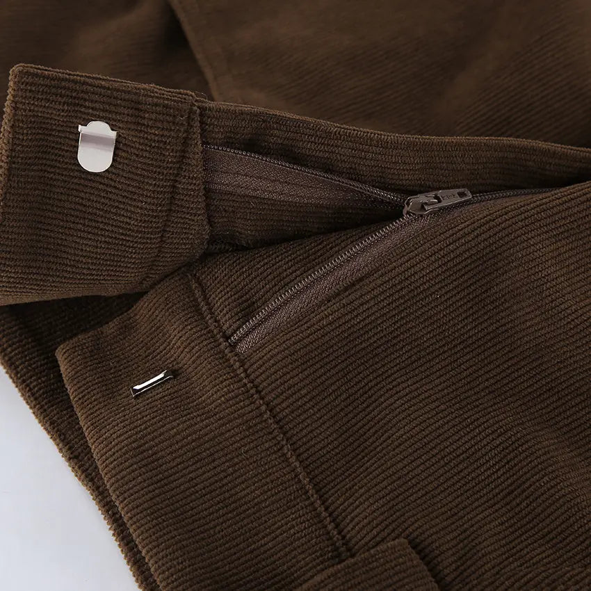 Brown corduroy mini skirt with matching belt featuring visible zipper and metallic hardware.