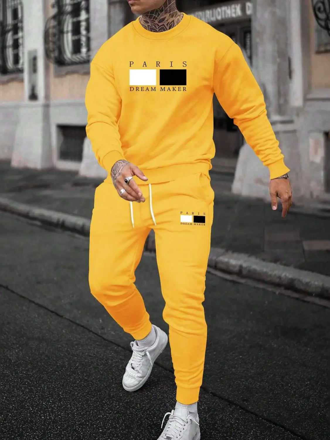 Bright yellow paris printed fleece hoodie featuring a paris dream maker graphic with a contrasting black and white rectangular design on the chest.