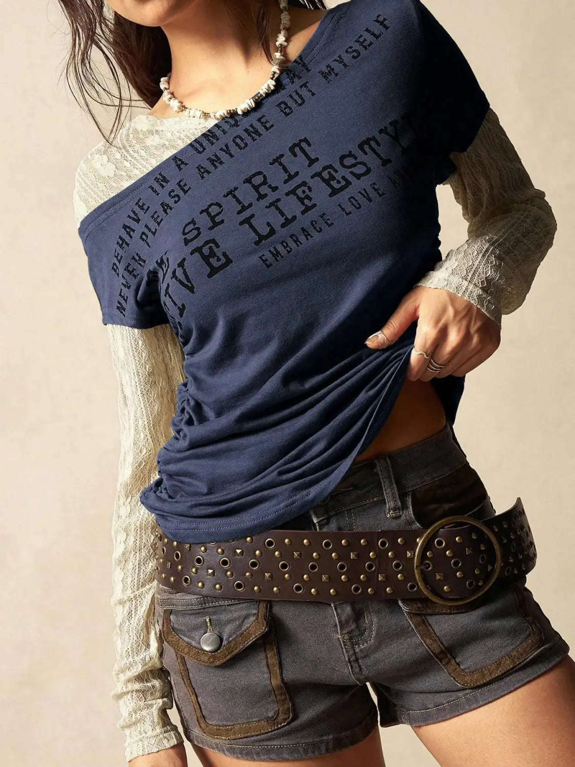 Navy blue short-sleeved knitted top with off-white lace sleeves and bold black text across the chest from the Lace Layer off Shoulder collection.