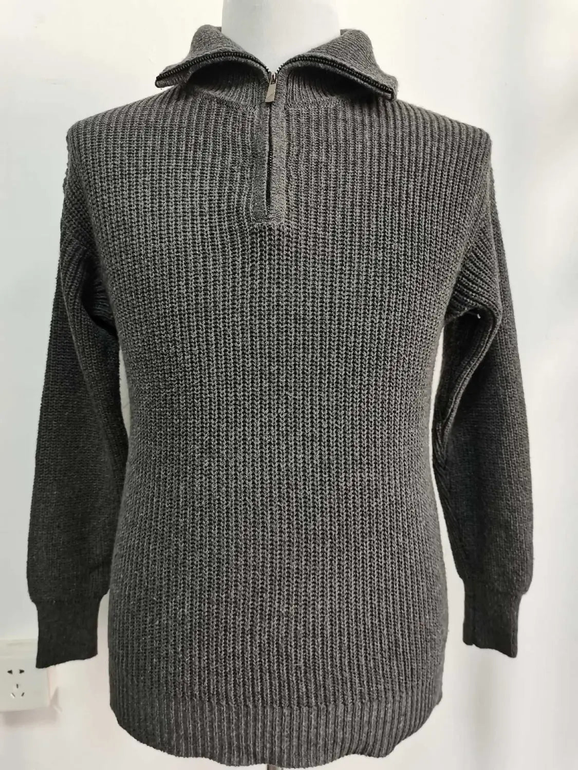 Dunkelgrauer Herren-Halbrollkragenrippstrickpullover aus Strickstoff mit Halb-Zippkragen und langen Ärmeln.