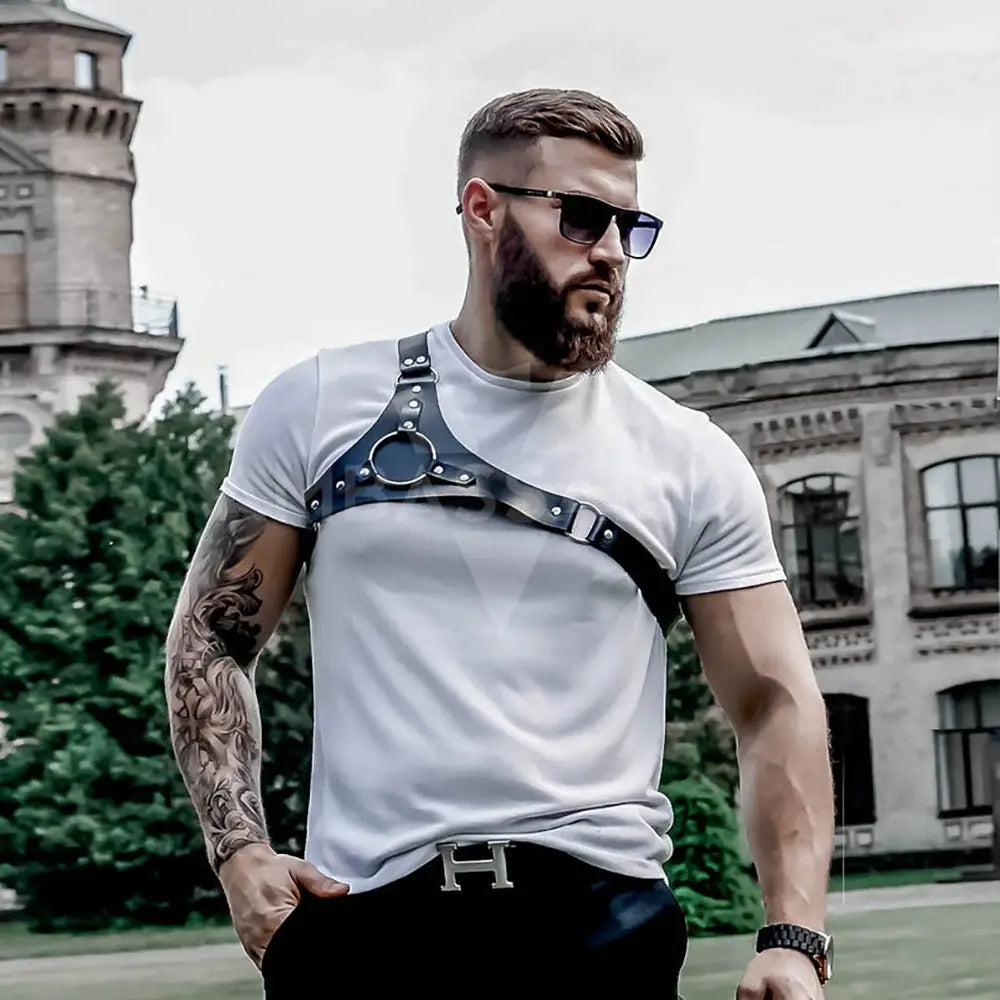 black leather studded dance harness with silver-toned buckles and metal hardware worn over a white t-shirt