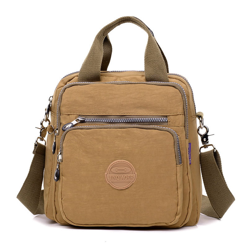 Tan canvas nylon messenger bag with olive green handles and adjustable strap featuring multiple zippered compartments and a circular brand logo patch.