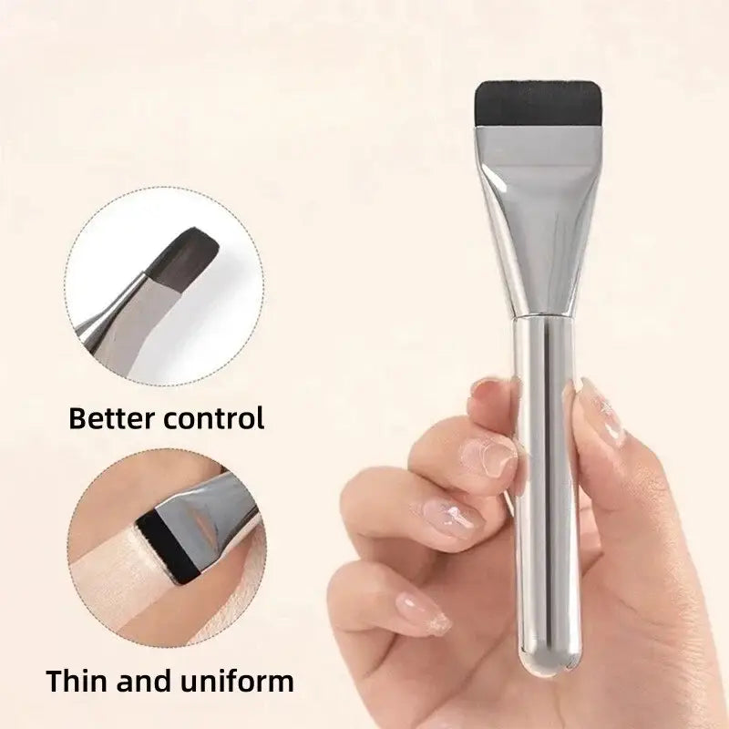 Ultra thin foundation brush with a silver-toned sleek cylindrical handle and a flat black-tipped applicator head for traceless makeup application.