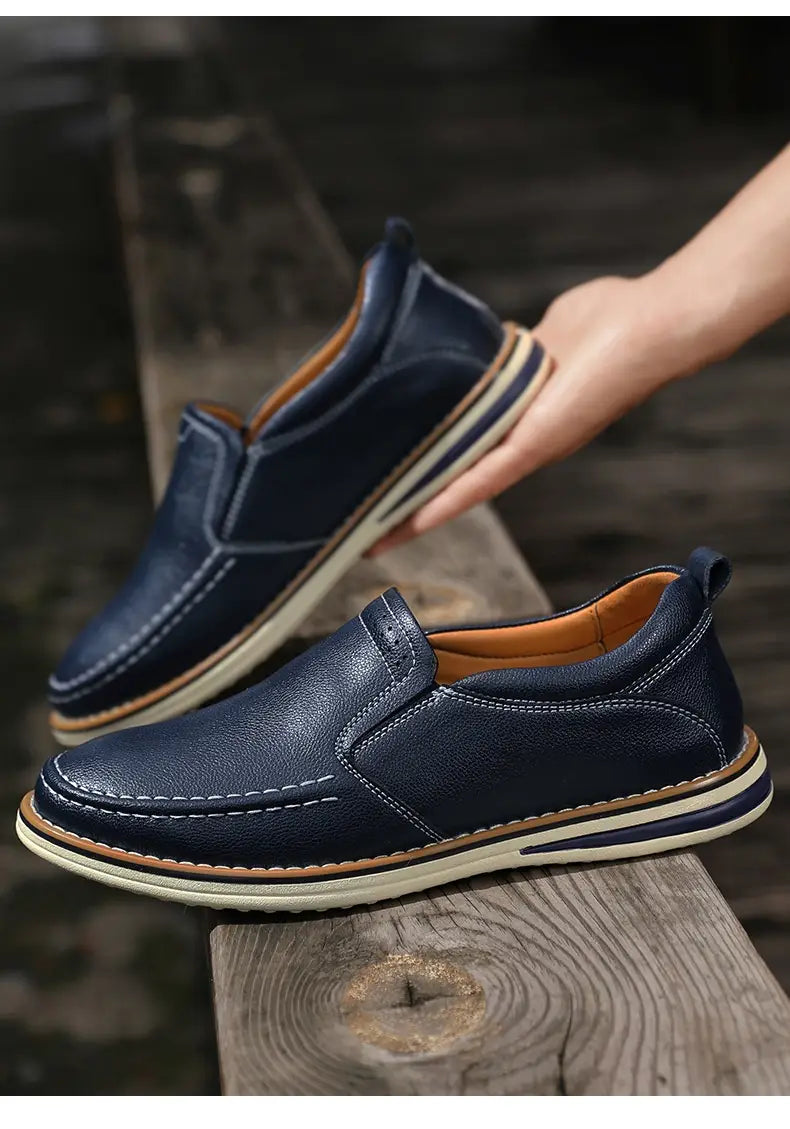 Dunkelblaue Lederschlupf-Loafer mit beigem Innenfutter und weißen Gummisohlen, entworfen als handgenähte legere Bean-Shoes.