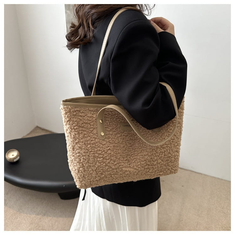 Brown faux fur tote bag featuring beige teddy bear-style material with tan leather handles and a small brand patch.