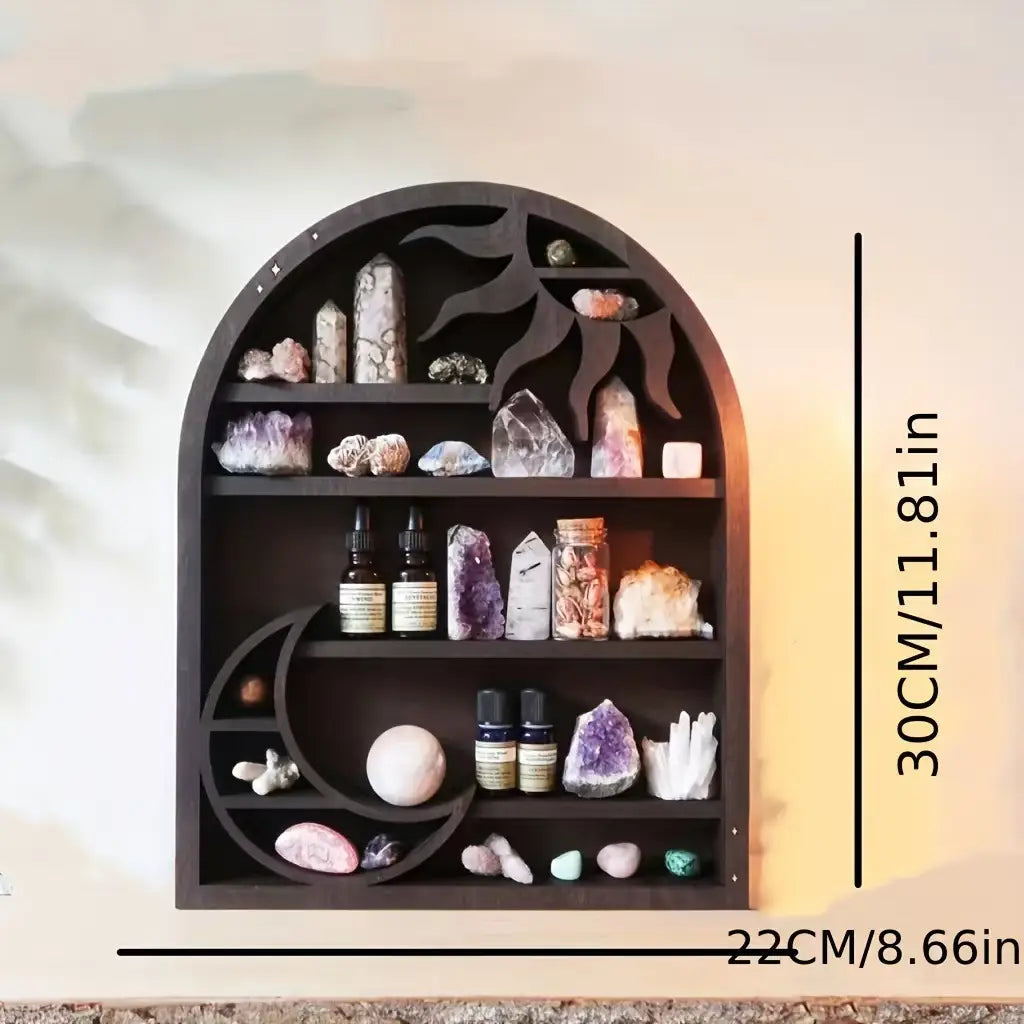 Dark wooden arched sun floating shelf with cutout sun and moon designs displaying crystals and essential oil bottles in black wooden crystal display rack.