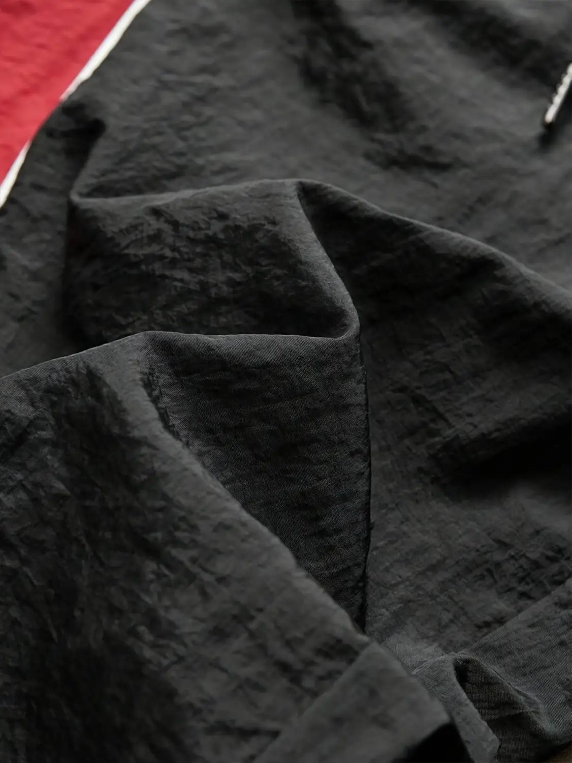 Black textured fabric with a subtle raised pattern on men quick dry athletic track pants designed for performance and comfort.