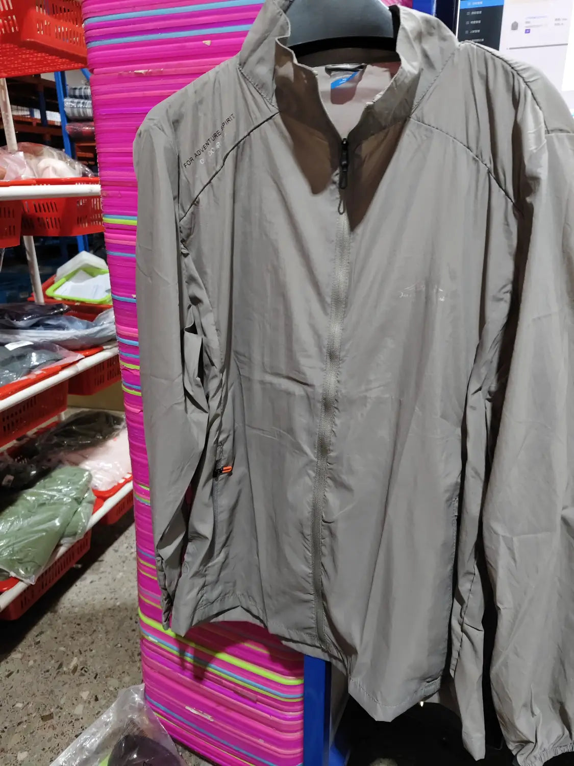 Men’s ultrathin sun protective sports jacket in gray lightweight material with a full-length zipper and subtle branding on the left chest.