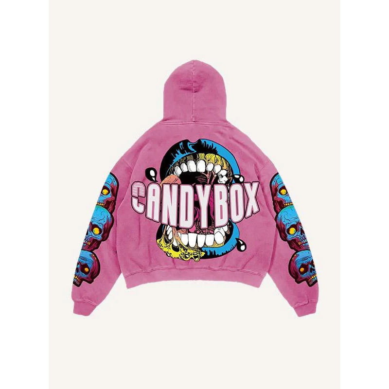 Sweat à capuche oversize de style streetwear à imprimé graphique rétro 3D pour hommes, de couleur rose, avec un graphisme éclatant d’une bouche ouverte, des dents et le mot « candybox » sur l’avant, ainsi que des crânes bleus imprimés sur les deux manches.