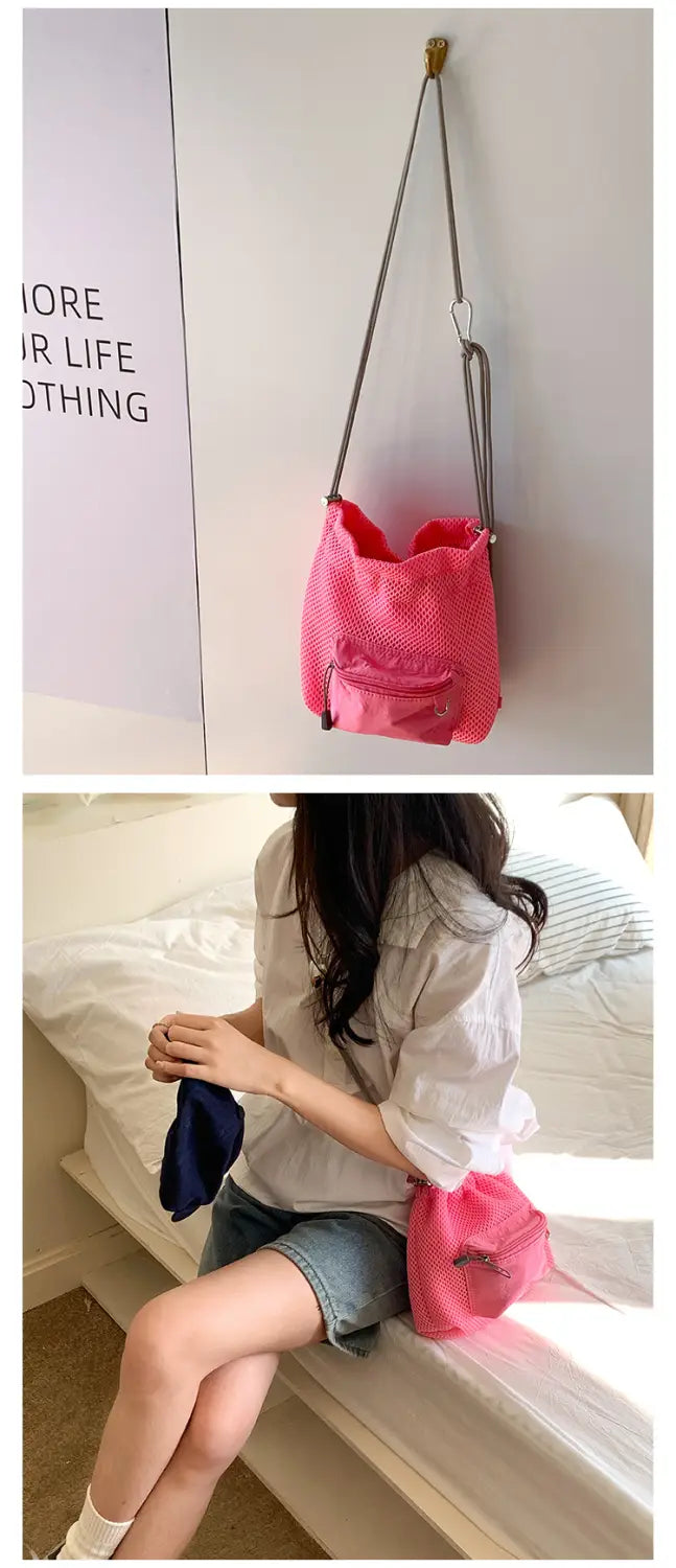 Mini pink mesh drawstring bucket bag featuring a vibrant pink mesh material with a silver-toned metal strap and zipper adorned with a heart charm.