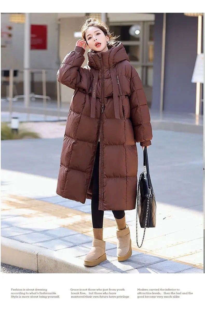 Women long hooded puffer coat in brown with quilted panels, front zipper, hood, and matching drawstrings.