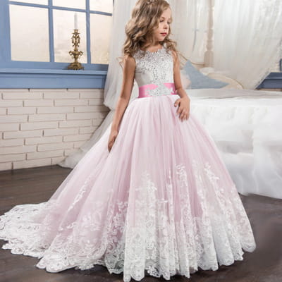 Ein zartes rosafarbenes und weißes Spitzenkleid für ein Blumenmädchen-Prinzessinnenkleid mit engan anliegendem Mieder, Satin-Schärpe und fließendem Tüllrock.