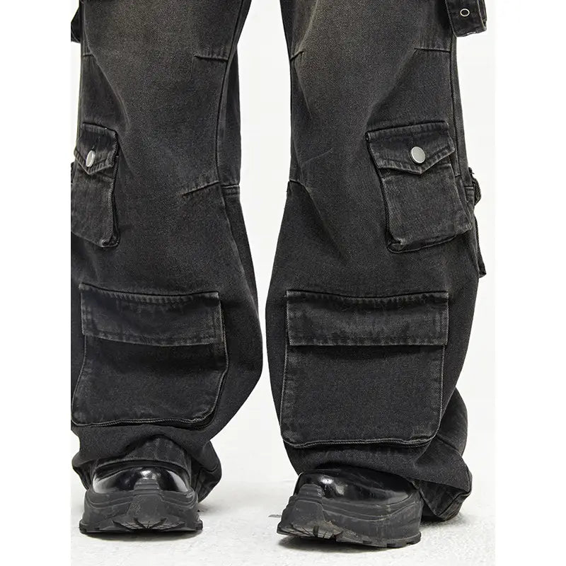 Men’s black distressed wide leg cargo jeans made of denim with multiple pockets and a faded look.