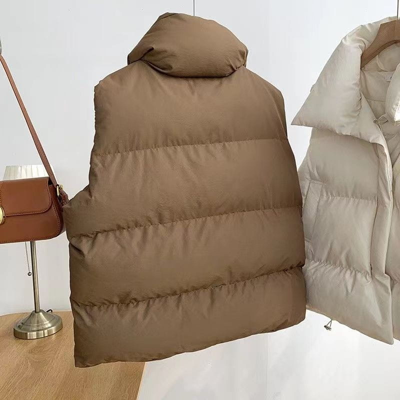 A cozy tan quilted puffer vest with a padded hood designed as loose sleeveless outerwear for women.