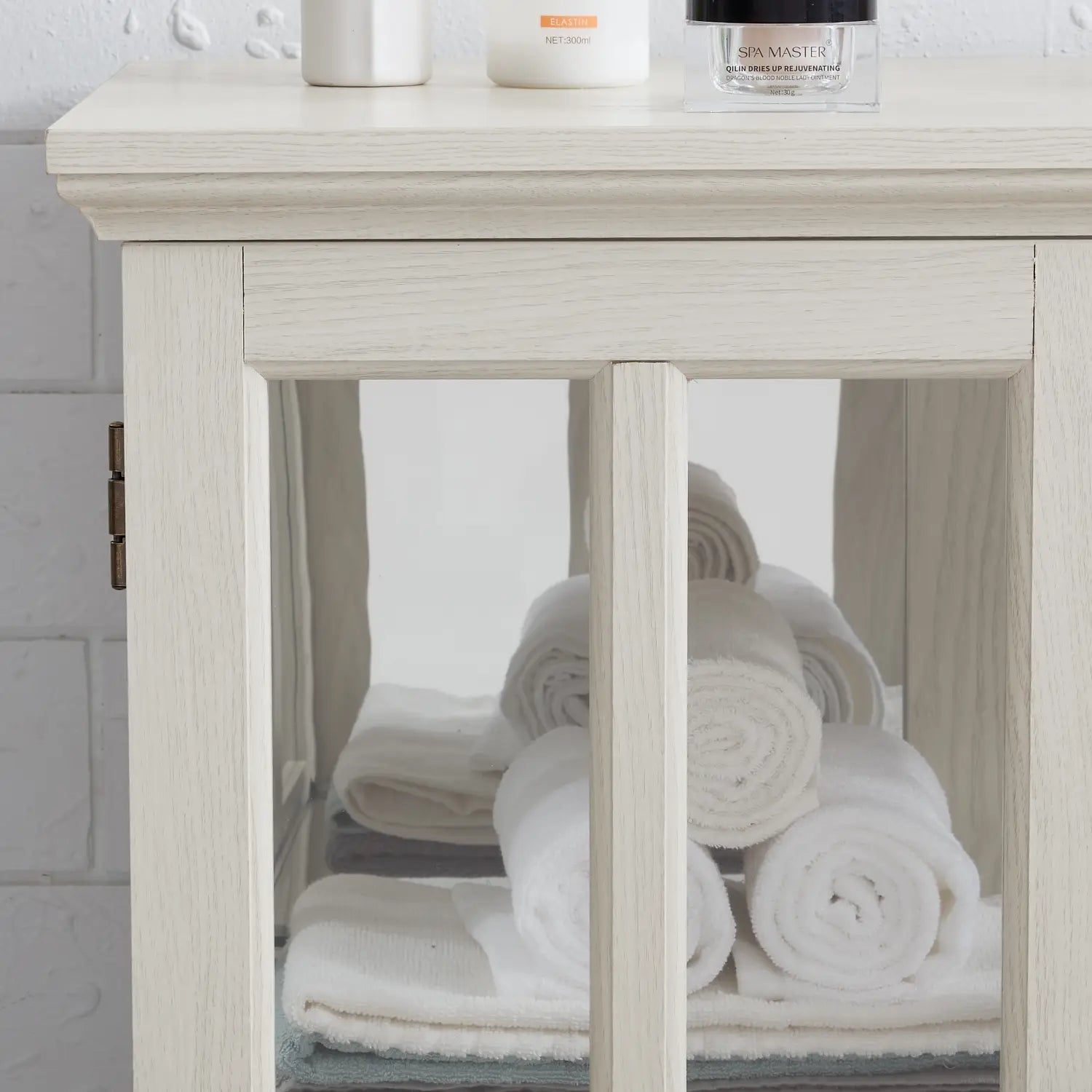 a light-colored wooden led curio display cabinet with white lattice glass doors and a clean minimalist design for bathroom storage