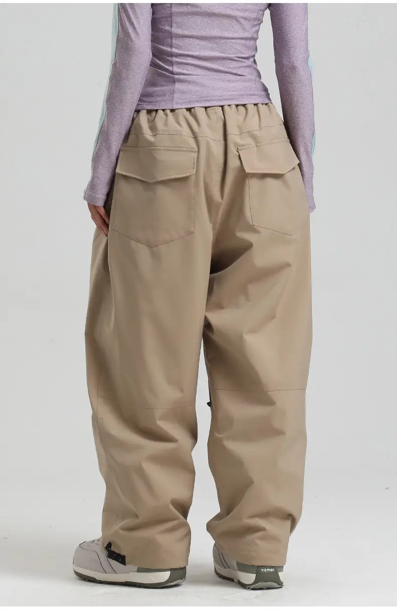 beige waterproof windproof snow pants shown from the back with wide-leg design, elastic waistband, and two large flap cargo pockets.