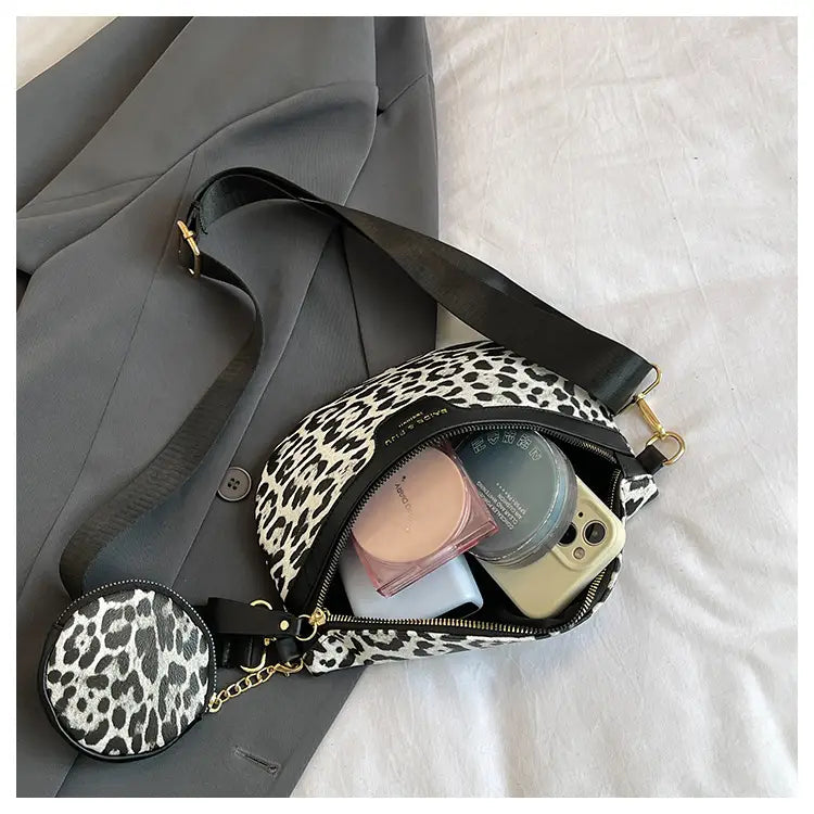 Sac banane à bandoulière imprimé léopard noir et blanc avec bordure en cuir et pochette à monnaie circulaire assortie, fixée par une chaîne.