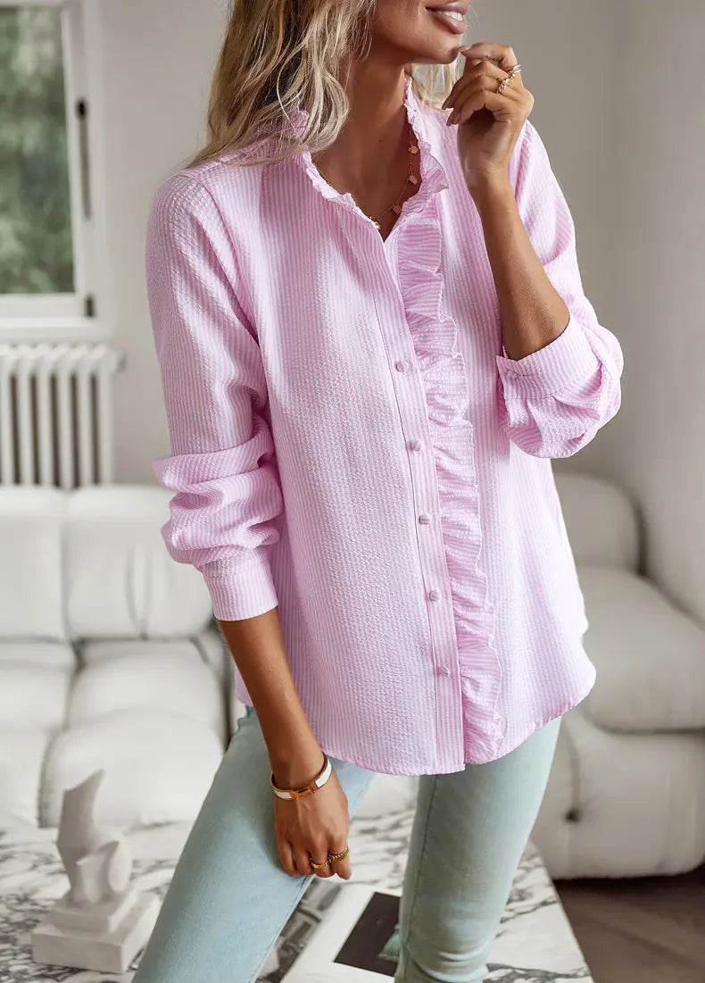 A soft pink ruffle trim textured long sleeve button up blouse with a subtle ribbed texture and delicate ruffled detailing along the front placket.
