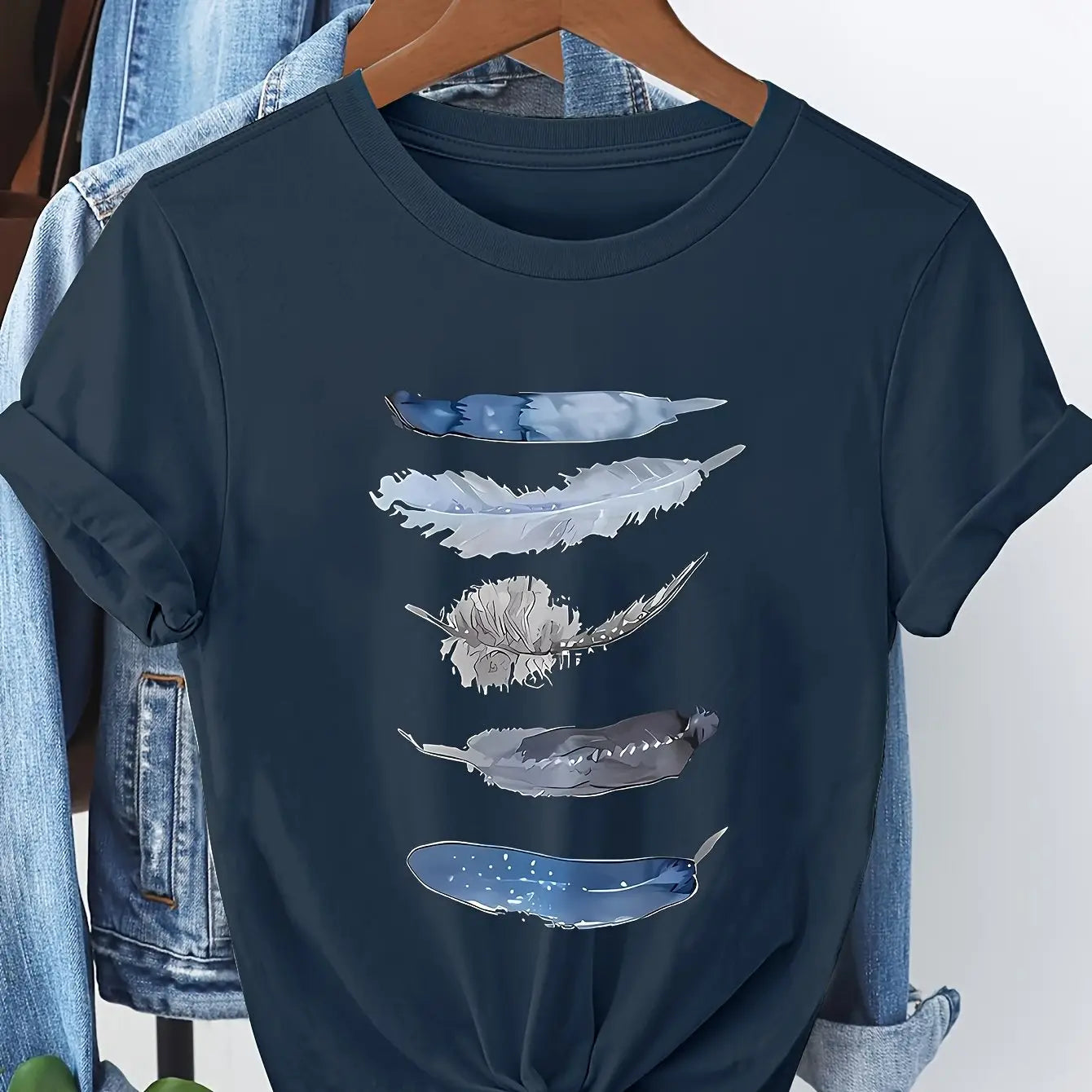 Dunkelblaues kurzärmeliges Damen-Baumwoll-T-Shirt mit einem Wasserfarben-ähnlichen Druck von fünf Federn in den Tönen Grauweiß und Hellblau.