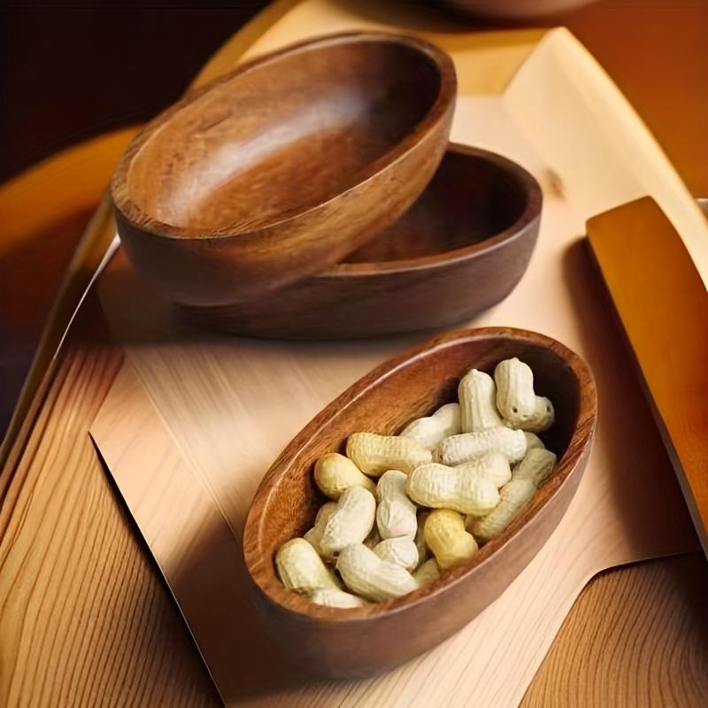 un cuenco rústico de madera artesanal con forma ovalada, lleno de cacahuetes, como parte de un set de barco de madera para sushi de un plato japonés