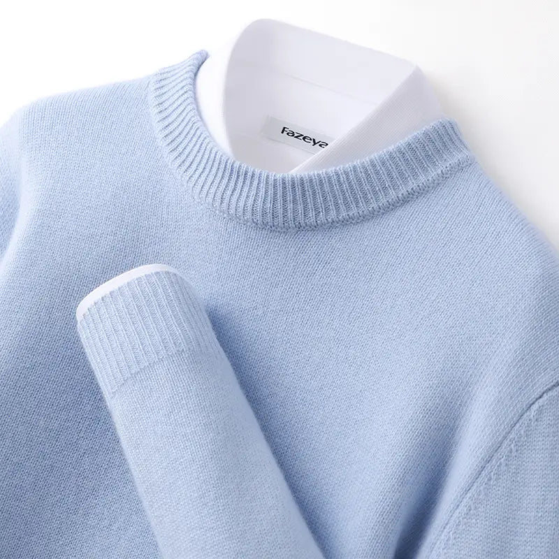 Hellblauer Strickpullover im Slim Fit mit Rundhalsausschnitt, gerippten Bündchen und geripptem Halsausschnitt, über einem weißen Hemd mit Kragen getragen.