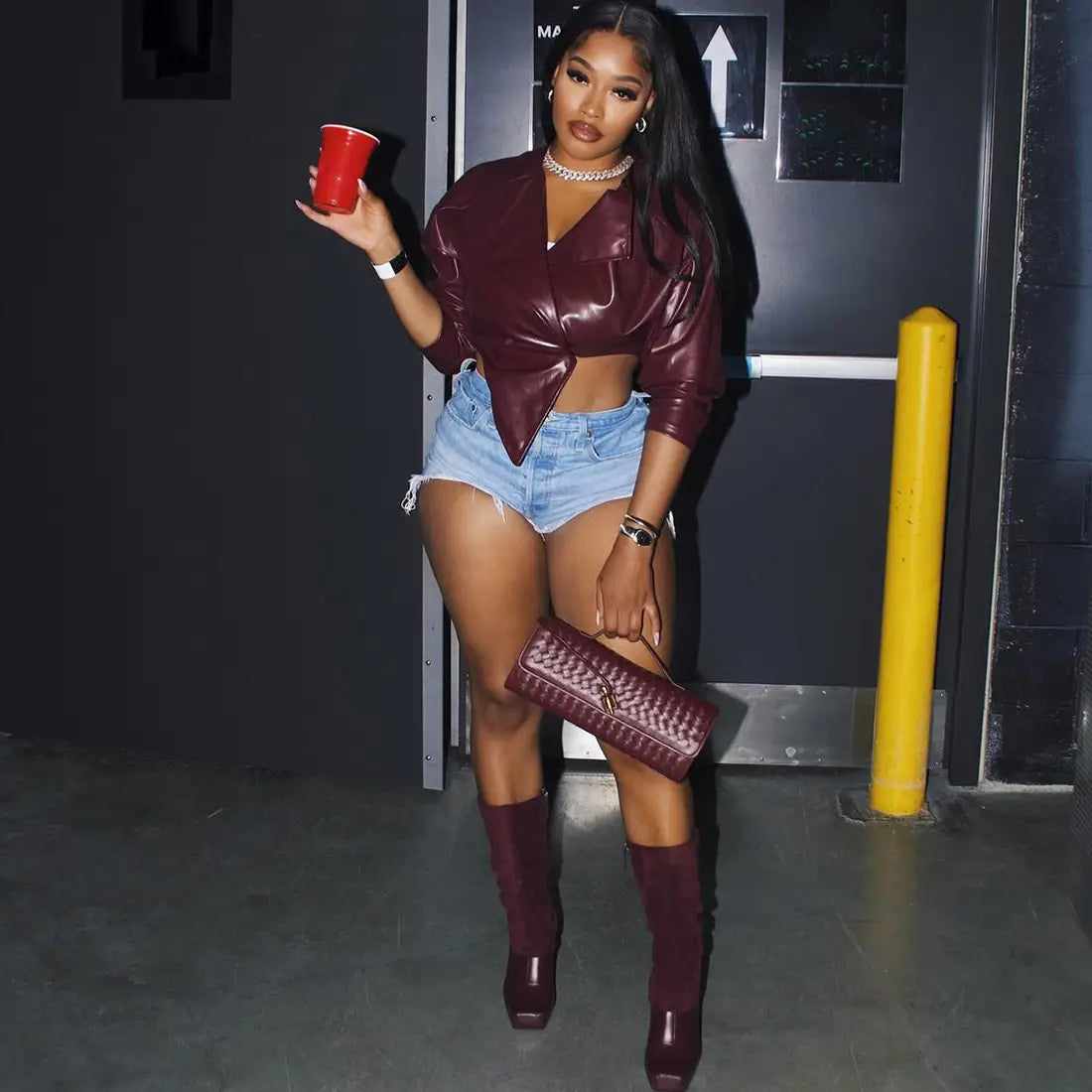 Maroon woven leather clutch complementing a faux leather cropped blazer for women in maroon.