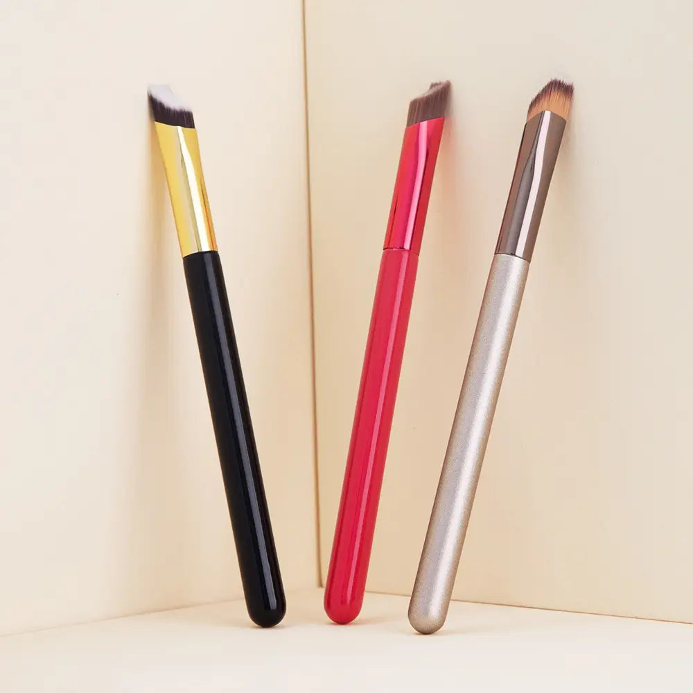 three angled wild eyebrow brushes with sleek glossy black gold red and silver handles designed as 3d stereoscopic makeup tools