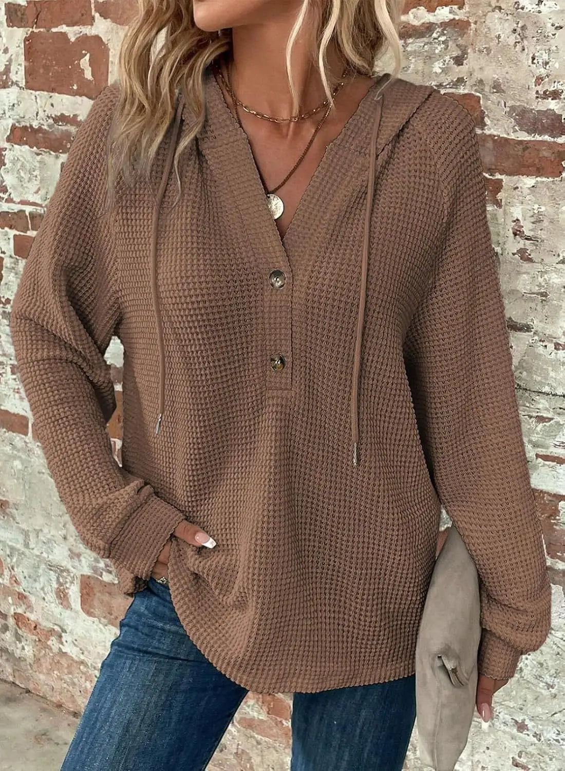 A cozy brown waffle knit hoodie sweater for women featuring a v-neck, front button closure, and drawstring hood.