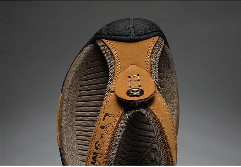 Men’s leather beach sandals outdoor sport flip flops in tan and brown leather with a black rubber toe cap and braided strap detail.